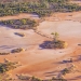 Isolated islands of scrub in red dirt pan