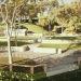 Digital concept image of a green, stepped picnic area with shade-giving gumtrees, paths, shaded barbecue areas, an amenities building and different grassy plots