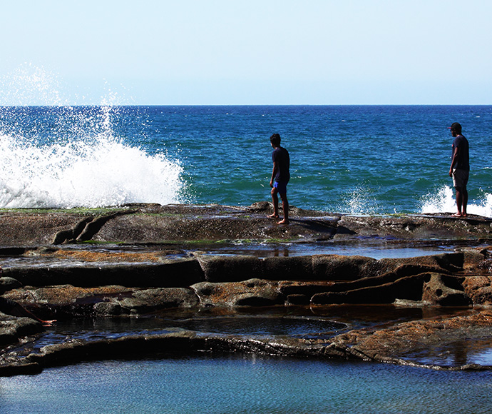 Visitors surprised by a large wave at Figure Eight Pools, Royal National Park.