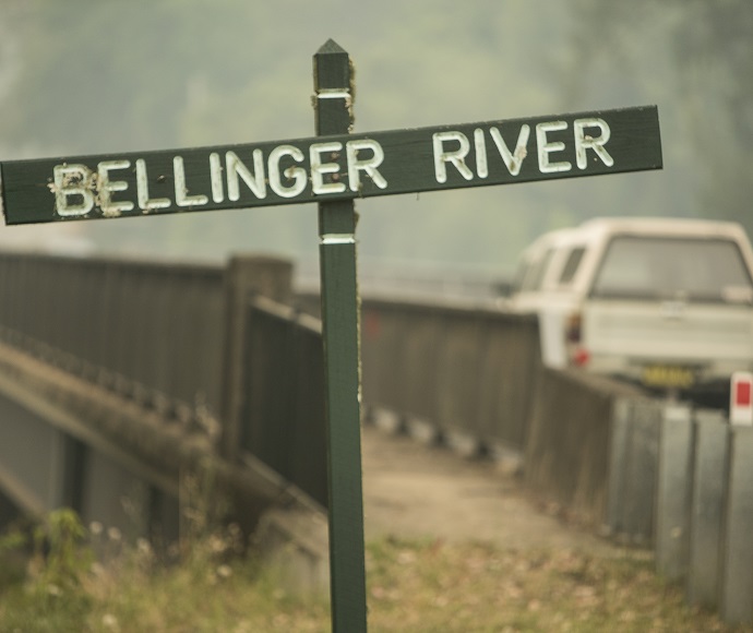 Bellinget River sign in the foreground and bridge and 4WD vehicle in the background. The Bellinger River snapping turtle is only found in a 60-kilometre stretch of the river