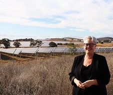 Minister Penny Sharpe, standing in front of solar panels in a field. 