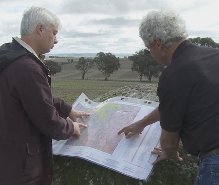 Two men looking at a soil map in the field