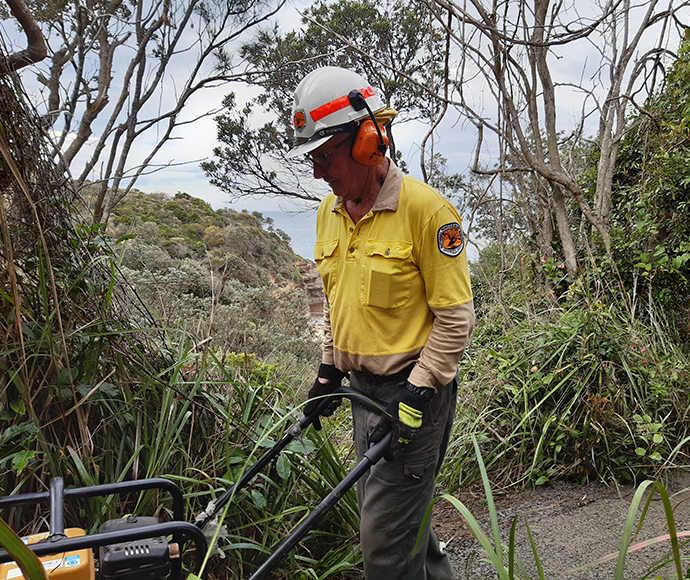 Field Officer, Lee Turbayne uses equipment that was flown in by helicopter to compact the new track surface, Bouddi Coastal Walk