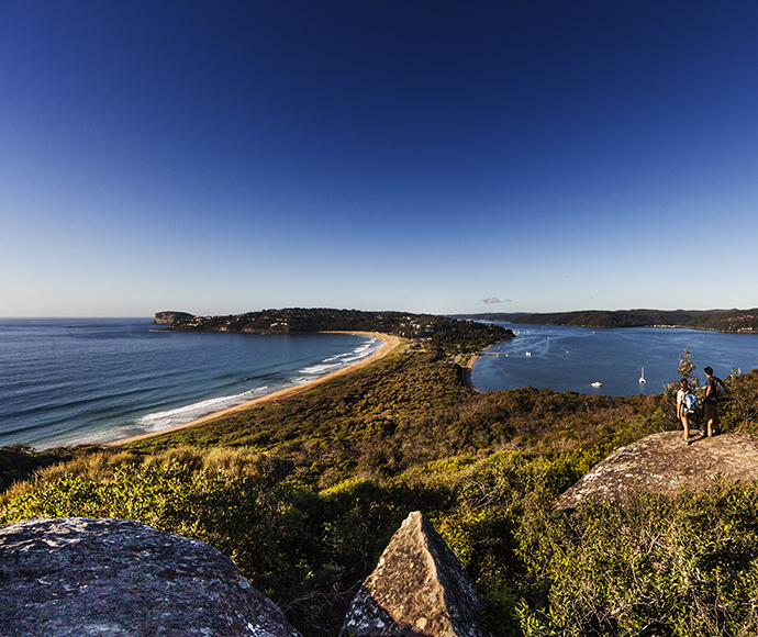 Walkers on rocky outcrop, Barrenjoey Lighthouse Track, overlooking Palm Beach.