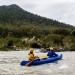 Volunteers paddle their canoe to site infested with weeds, Kosciuszko National Park. Bush regeneration