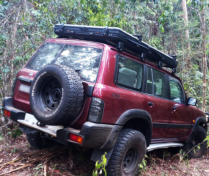 Maroon 4WD parked on a slope.