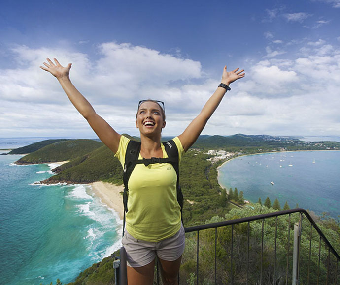 Woman reaching Tomaree Head Summit, Mount Tomaree, Port Stephens.