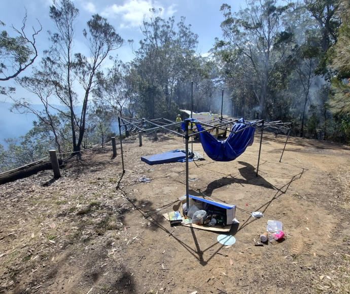 Abandoned campsite with smouldering bush behind