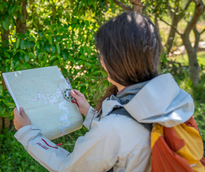 Woman bushwalking holding a map and compass
