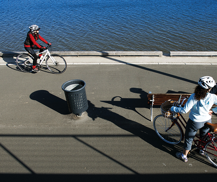 Cyclists ride along the waterside of Parramatta River. Rhodes, Sydney, NSW.
