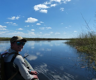 Person in canoe on blue water in the Eulimbah Wetlands.