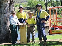 People standing with a nest box on the ground