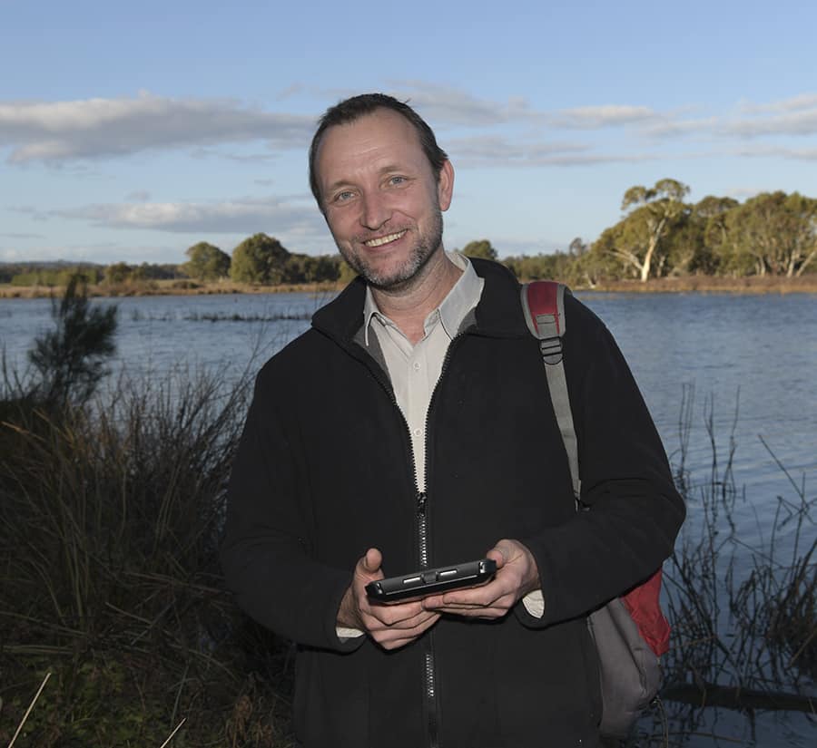 Joe Stammers standing beside a lake