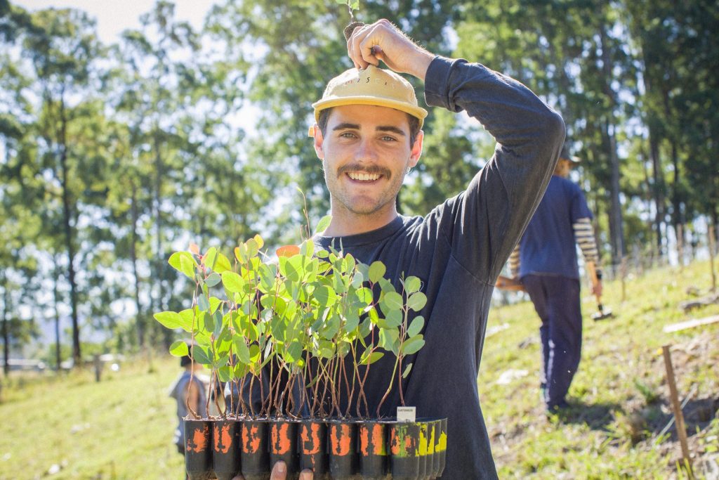 A man with tree saplings ready to plant