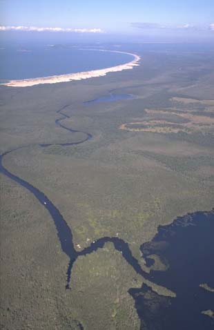 Aerial view of Myall River flowing into the ocean, with visible sandbanks at the river mouth.