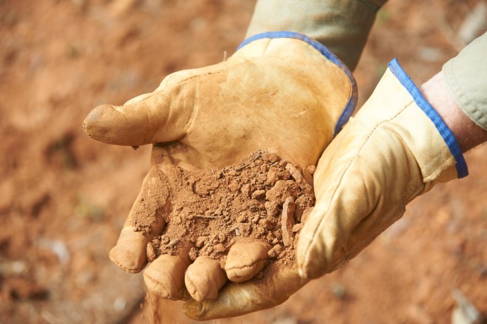 Gloved hands holding soil being sampled for testing