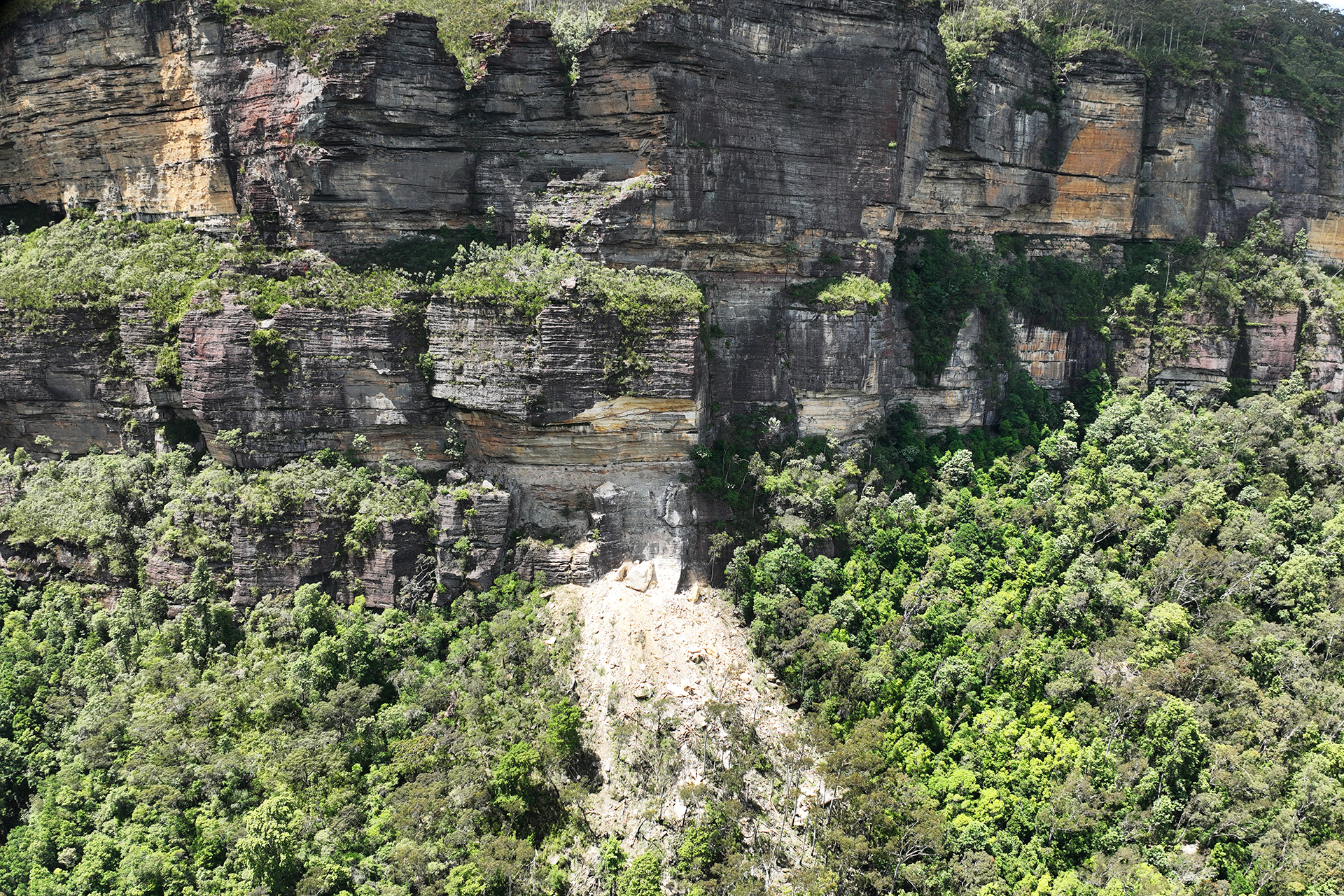 Scree of rocks spreading from cliff base