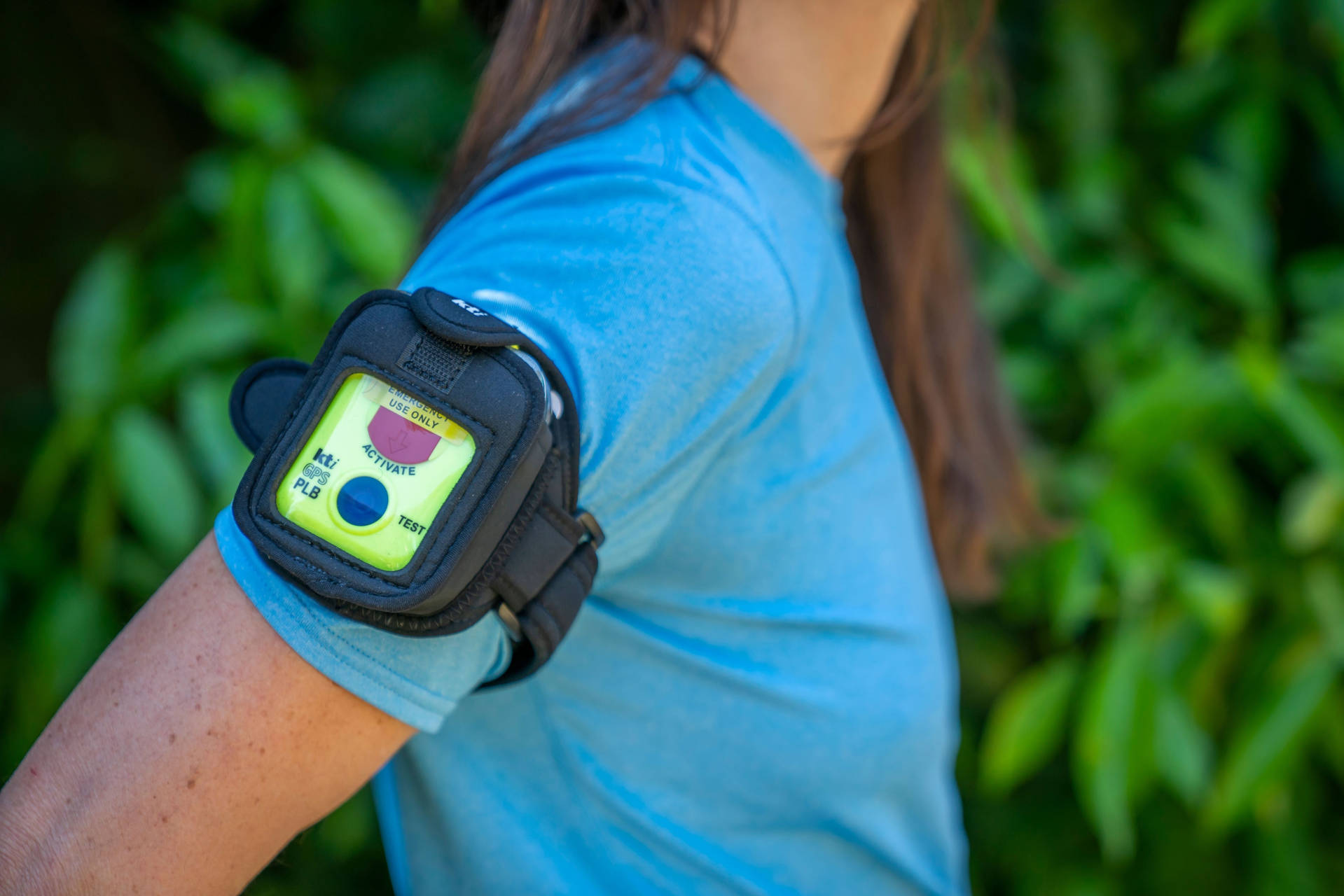 A person wearing a personal locator beacon strapped to their upper arm.