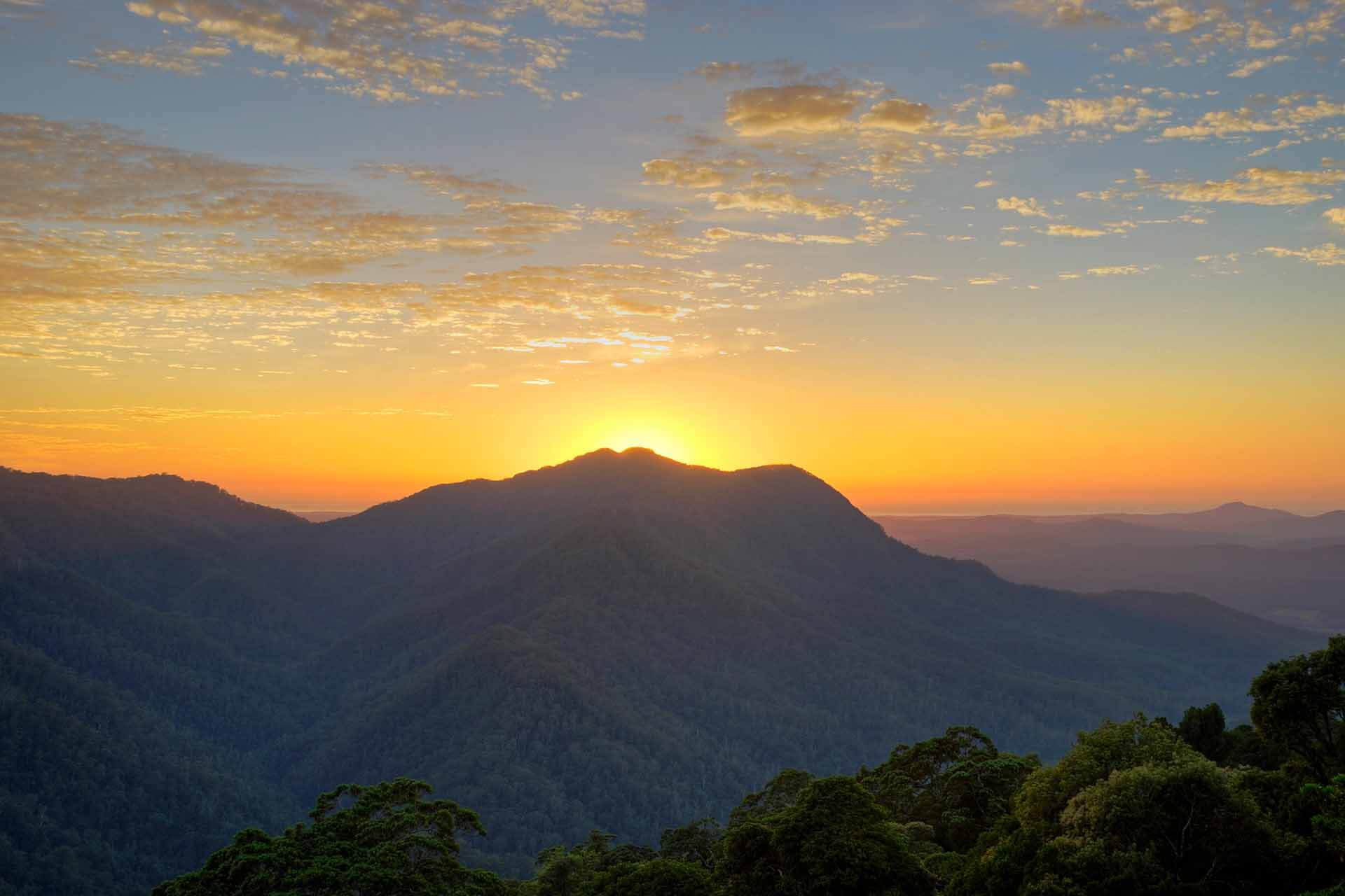 View of sun setting behind mountains