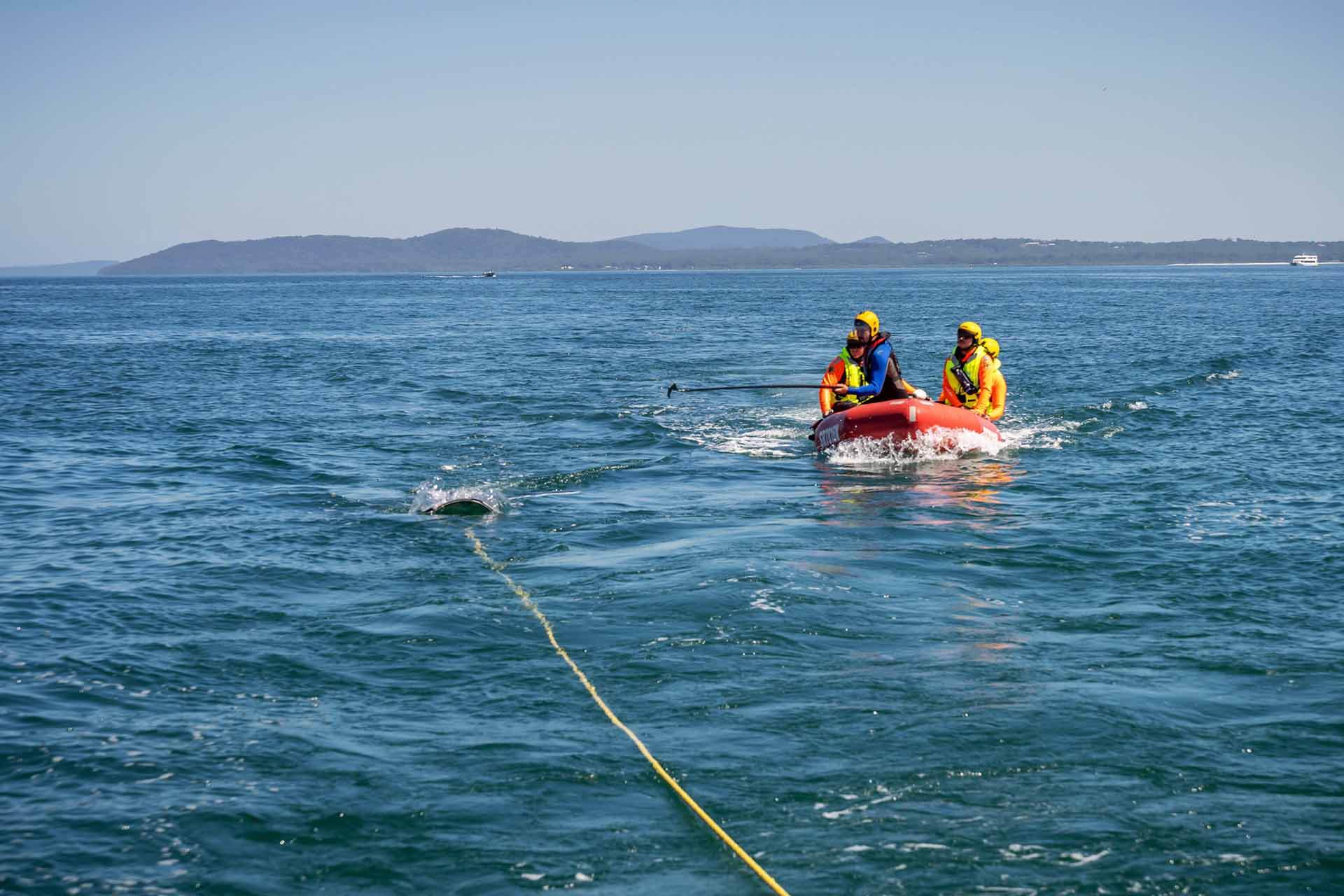 NPWS crew in a raft following a trailing line in the water.