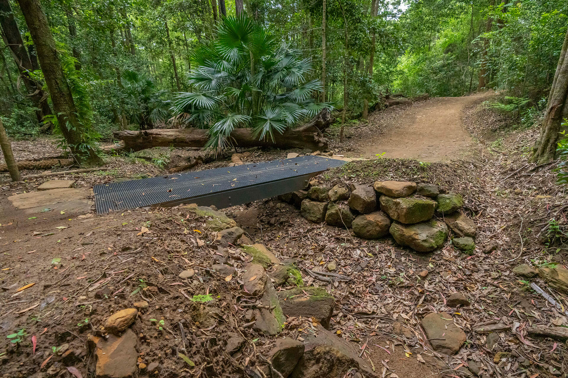 A metal bridge over a dry creek bed