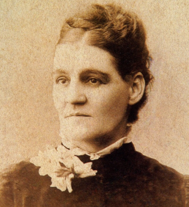 A black and white photo of a woman. She has a serious expression and is not looking at the camera.
