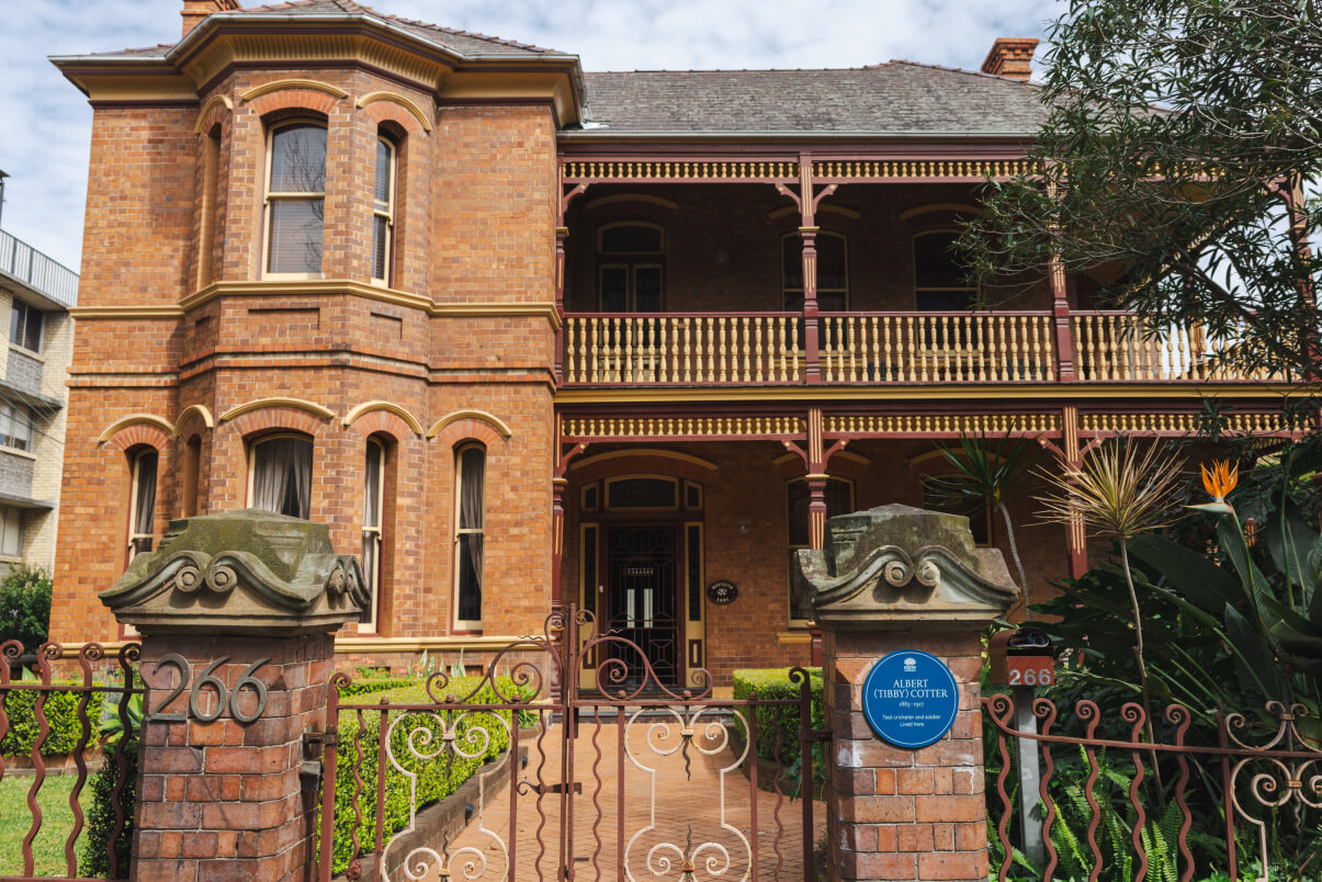 Blue Plaque commemorating Tibby Cotter mounted on the exterior of Monteith, a heritage-listed two-storey brick residence in Glebe, Sydney. The plaque is affixed to the red-brick façade of the house, which was built after 1890 as the home of the Cotter family. Monteith is situated on a rectangular plot on the western side of Glebe Point Road.