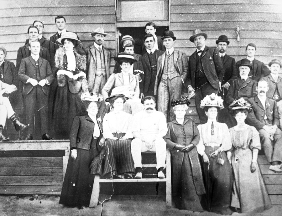 Black and white group photo taken at the official opening of the Bondi Surf Bathers Life Saving Clubhouse at Bondi Beach on 2 November 1907. Men are dressed in suits and hats, while women wear long dresses and wide-brimmed hats, gathered in front of the newly opened clubhouse.