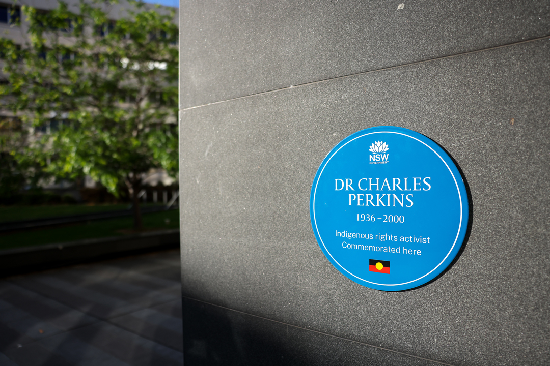 Blue Plaque for Charles Perkins on a grey wall. The plaque reads: 'Indigenous rights activist. Commemorated here."