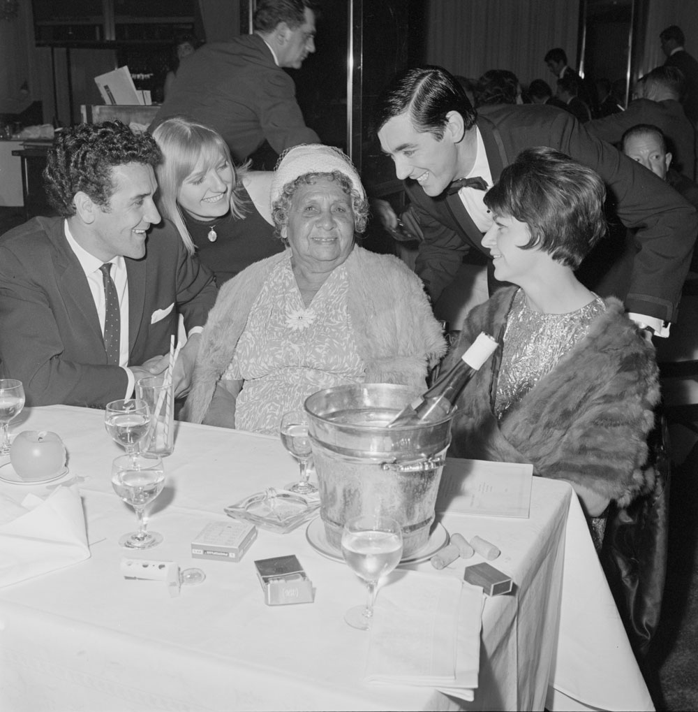 A black-and-white photograph of Charles Perkins and members of his family enjoying a night out at the Silver Spade Room at the Chevron Hilton Hotel, Sydney, May 1966.
