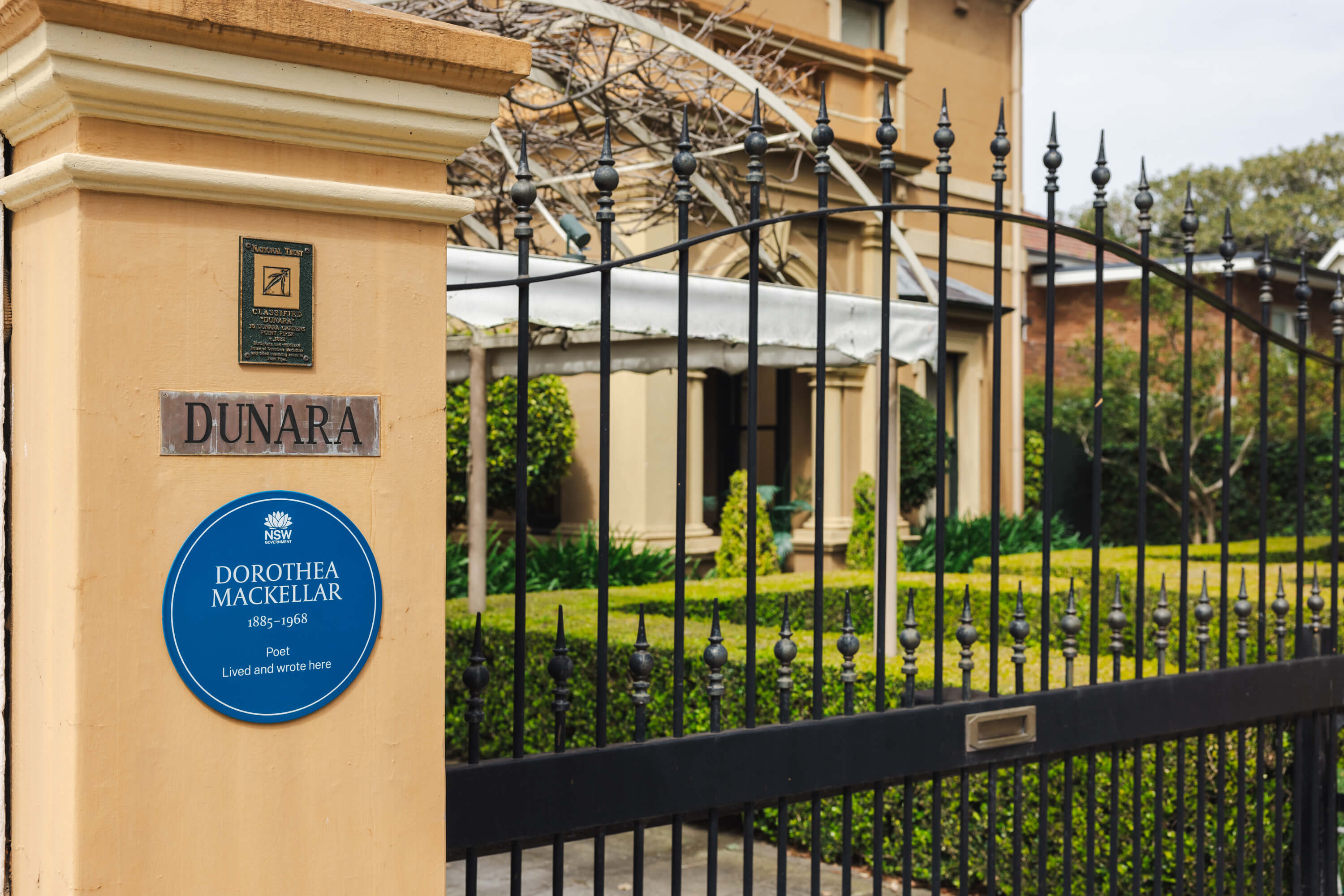 Dorothea Mackellar's Blue Plaque on a yellow post outside a grand old house