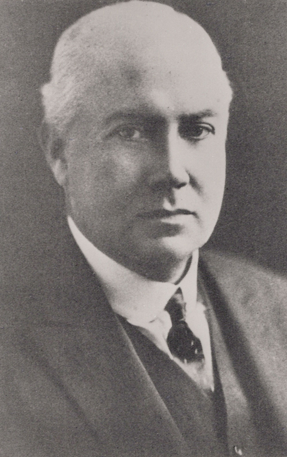 A formal portrait of Dr Mark Cowley Lidwill in a dark suit and tie. Photo courtesy of The Royal Australasian College of Physicians. Photographer unknown.