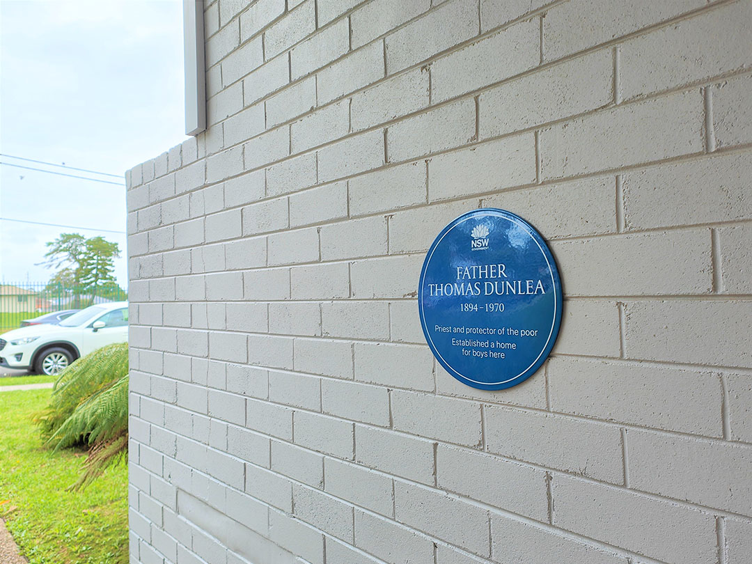 Brick wall at Dunlea Centre with a blue plaque
