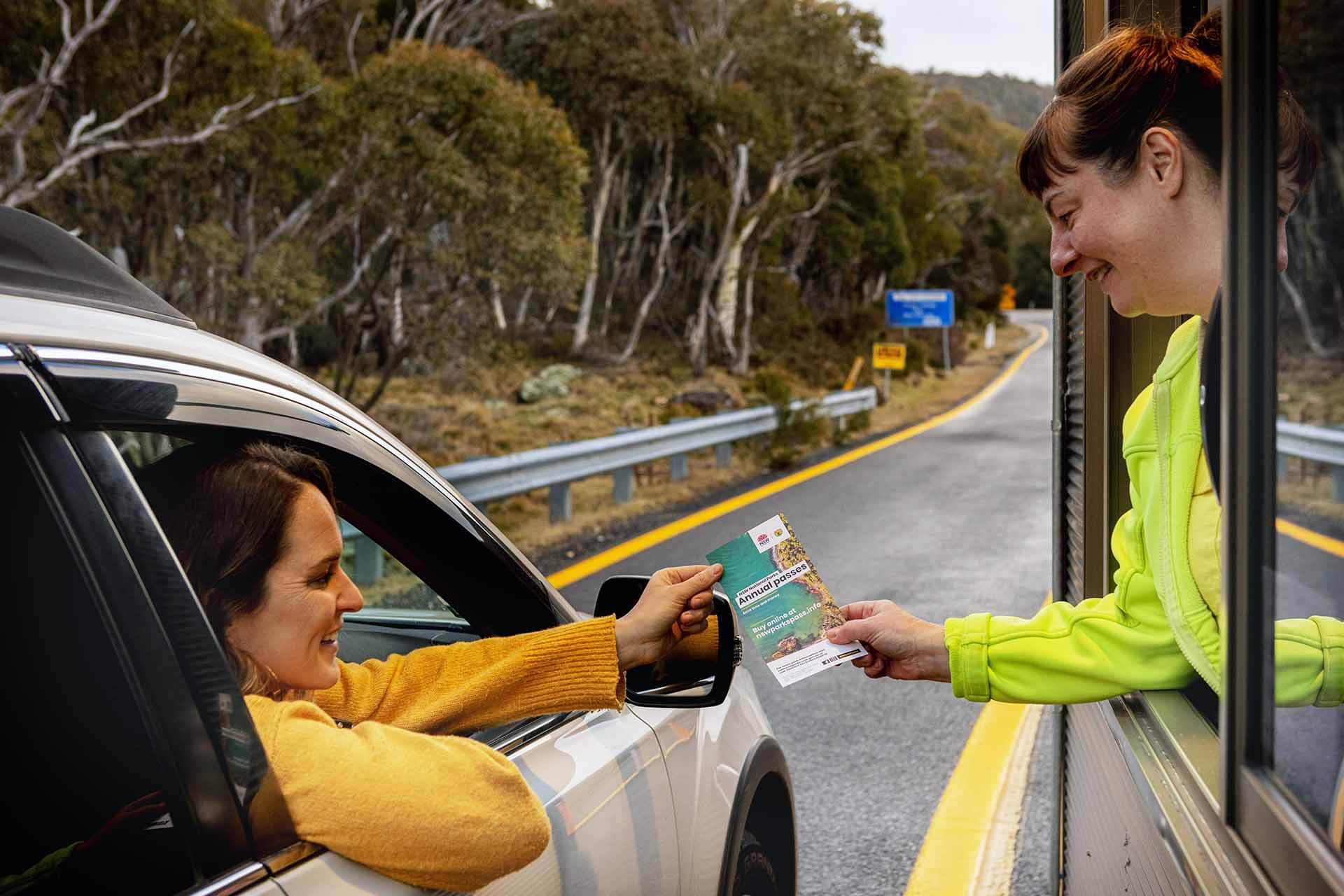 NPWS officer scanning pass held up vy woman leaning out of driver-side window