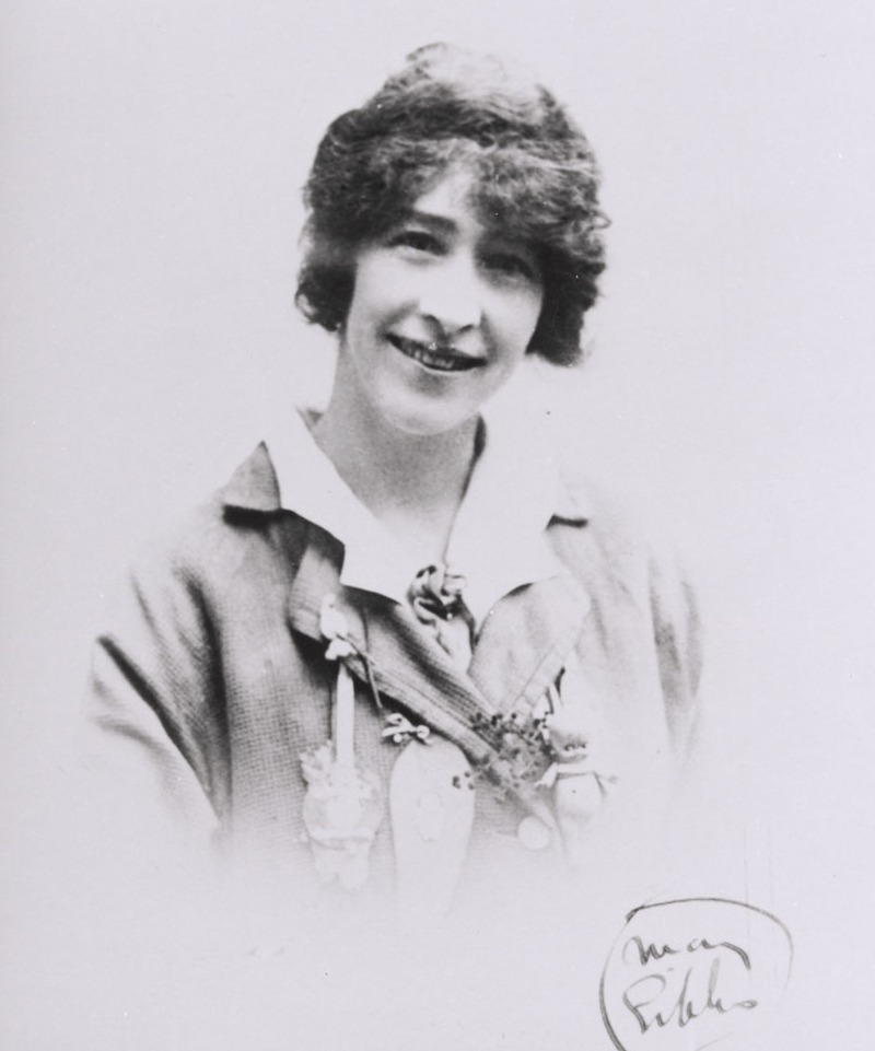 Head and shoulders black and white photo of a young woman with short wavy hair