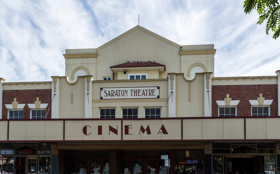 Photograph of the top level of the two storey Saraton Theatre building. The façade features a prominent sign reading “Saraton Theatre” on the first level, while another sign labeled “Cinema” is positioned between the ground floor and the first level. The building has a classic architectural style, reflecting its historical significance as a local entertainment venue.