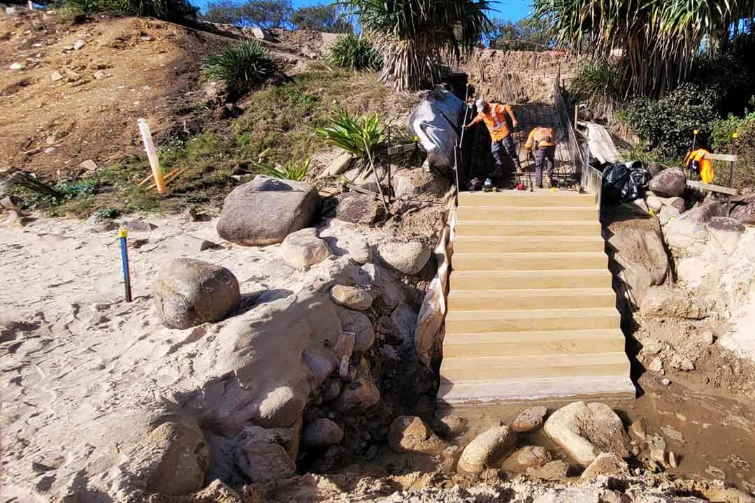 Men working on a flight of concrete steps.