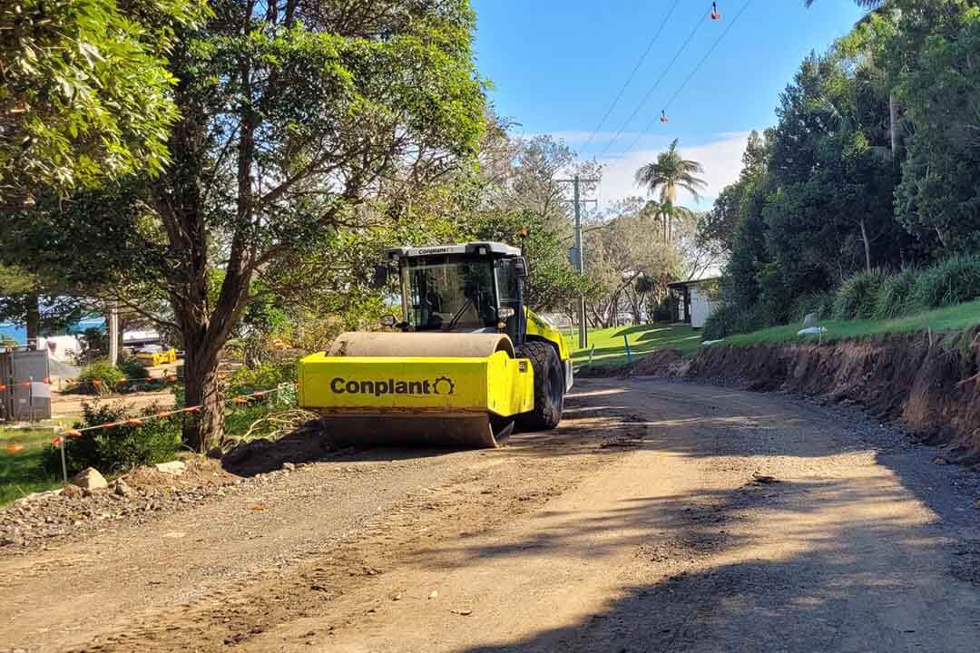 Yellow machinery working on a dirt road