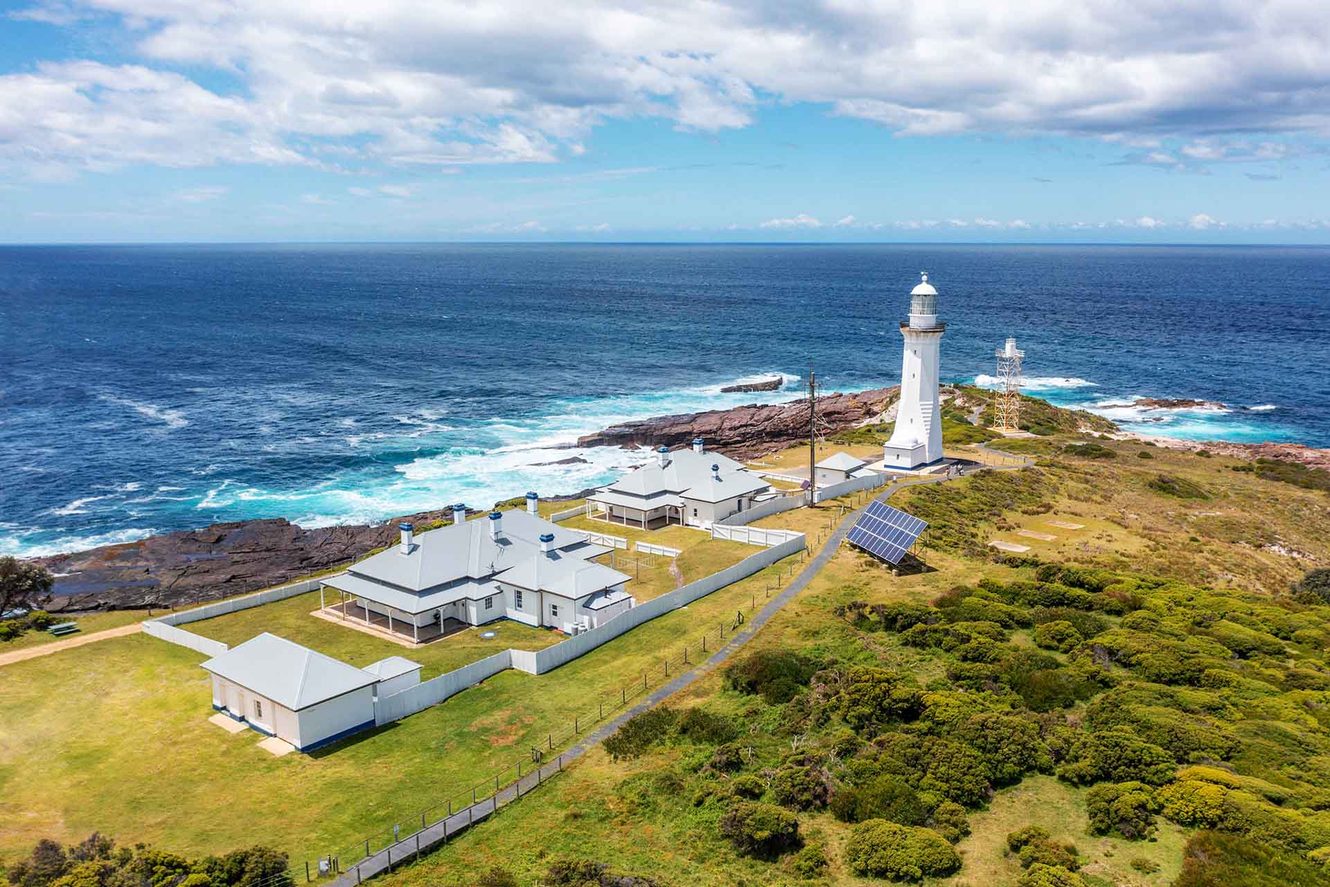 Lighthouse and associated buildings on coast.