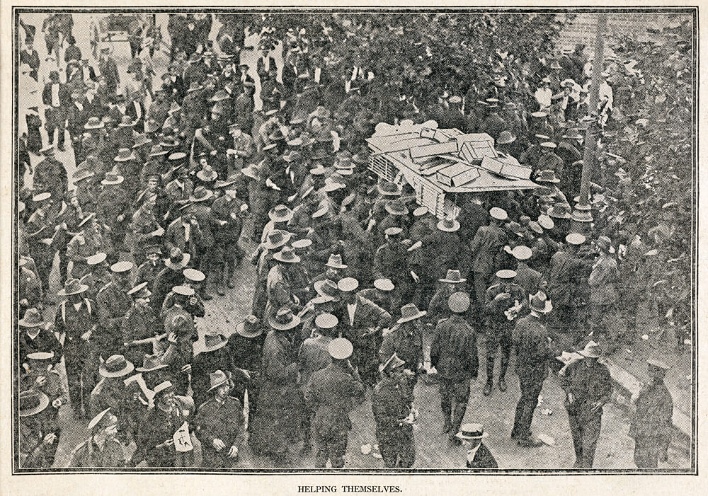 Black and white image of a massive group of soldiers rioting in the street, looting cordial carts and fruit and vegetable carts. Below the image reads ‘HELPING THEMSELVES’.