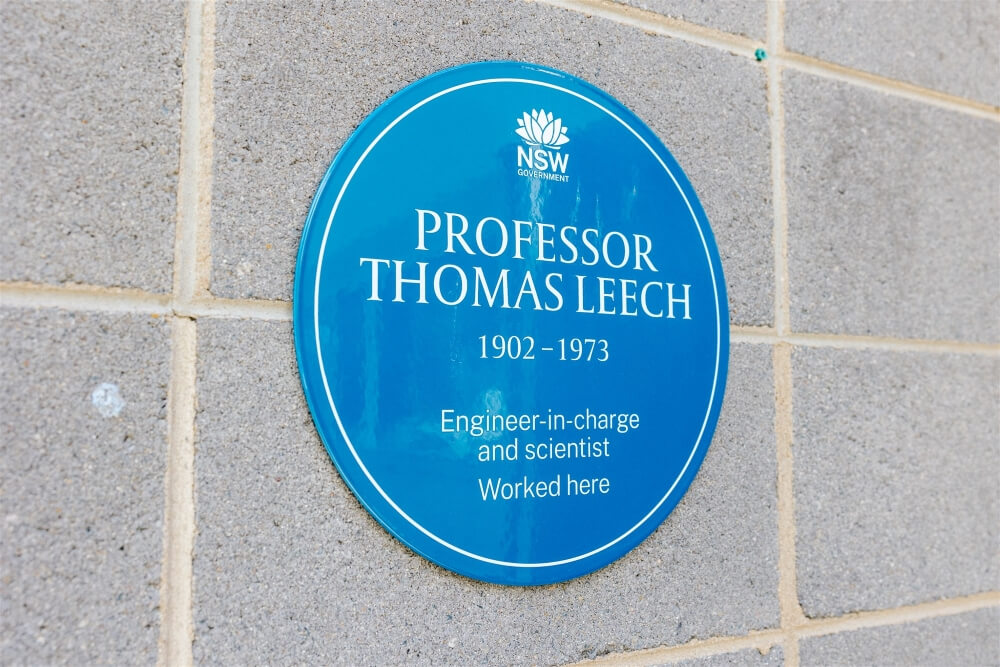 Blue Plaque on a grey brick wall. Plaque reads 'PROFESSOR THOMAS LEECH' '1902 - 1973' 'Engineer-in-charge and scientist' 'Worked here'.