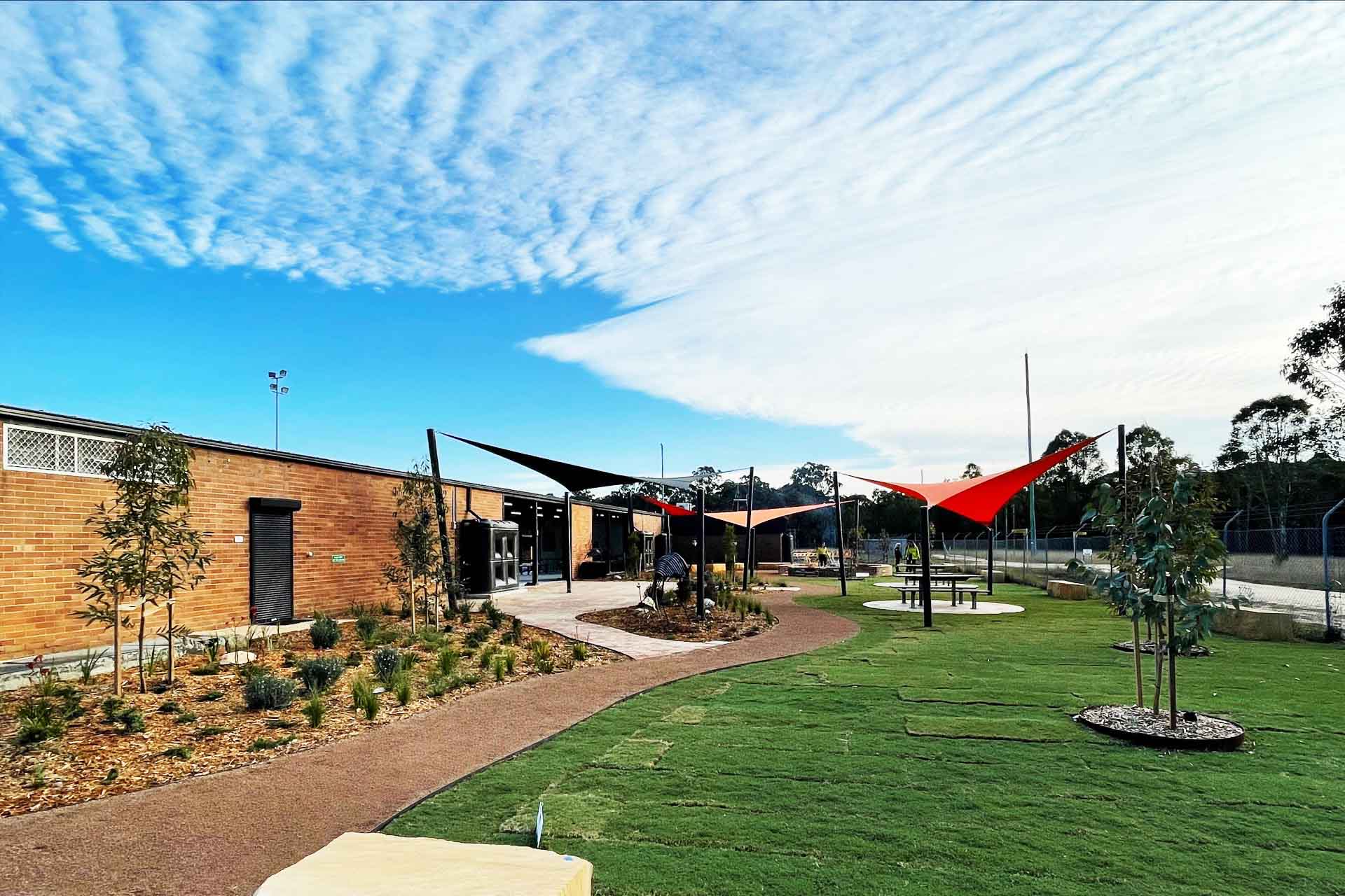 Brick building with newly landscaped garden and lawn in foreground.