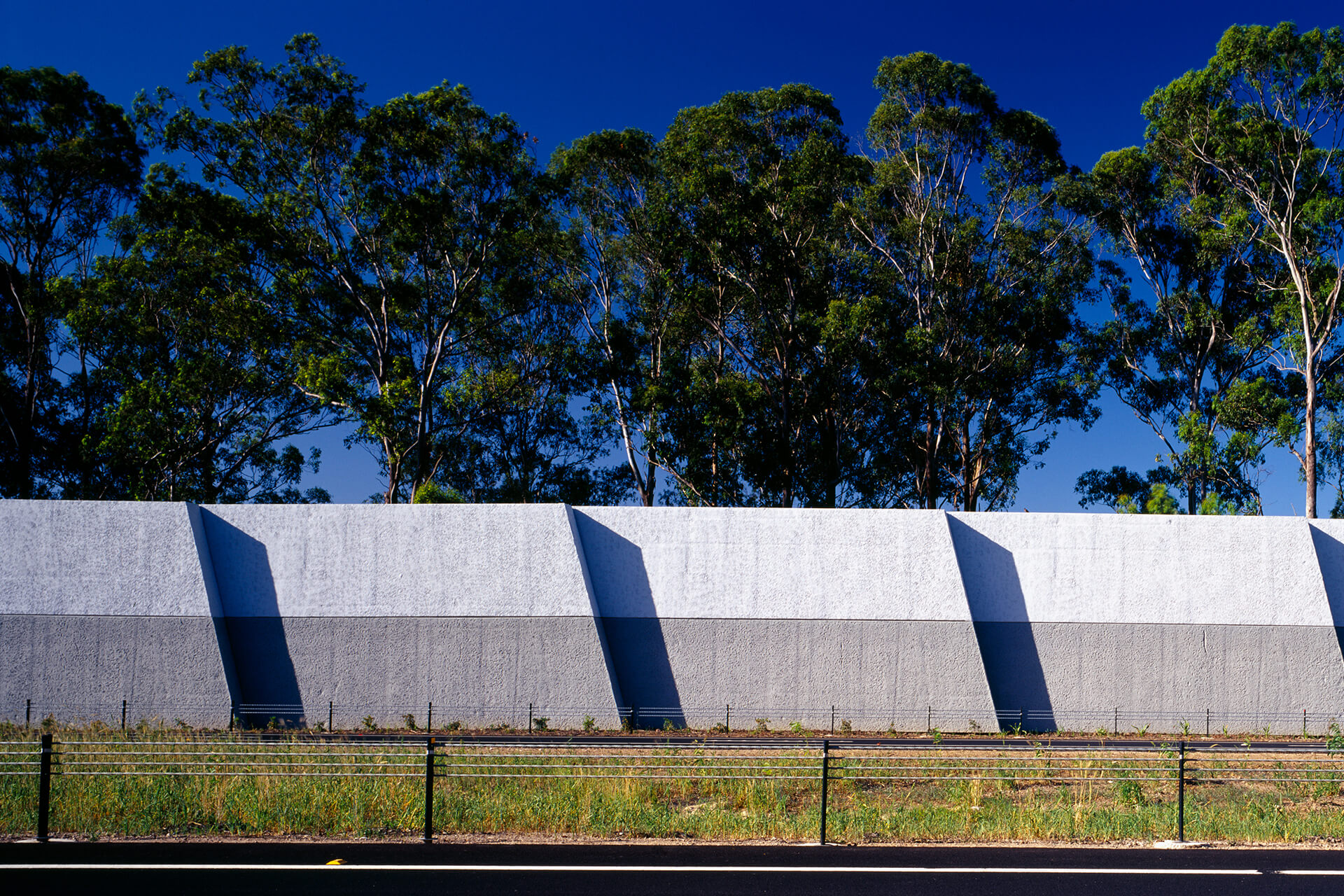 Featureless concrete walls, some trees behind.
