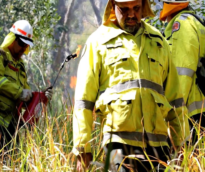 Three people in fire uniforms start a cultural burn at Grassy Spur