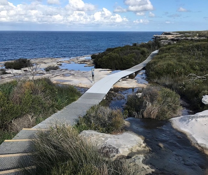 Cape Baily track upgrade, Kamay Botany National Park. Metal, slightly raised track with shallow stairs following the coastline.