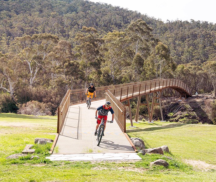 Two cyclists completing a bridge crossing